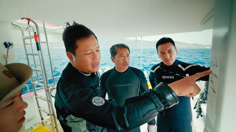 景白（中）與王陽明（右）在下水前，由戒護暨技術潛水教練（左）解說路線及注意事項。（公視提供）