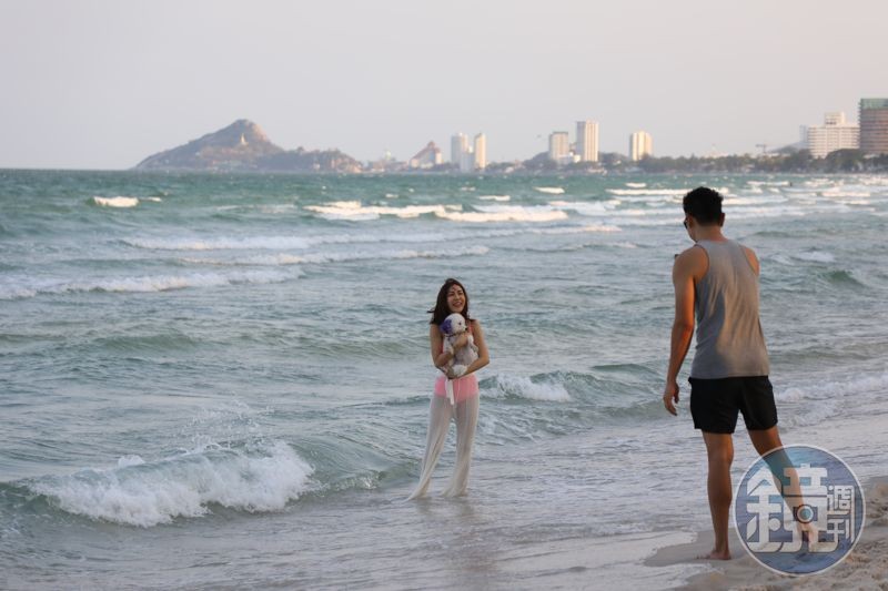 美女遊客帶著愛犬來海邊散步游泳。