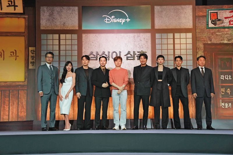 編導申延植（中）率領《逆貧大叔》主要演員們在韓國出席記者會，期待觀眾能透過作品看到不同時代的韓國。（Disney+提供）