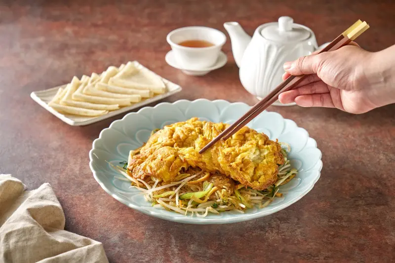 ▲老北京傳統菜餚「合菜戴帽」是將滿滿新鮮的鮮菜絲以大火快炒，再加上金黃烘蛋。（圖／六福萬怡提供）