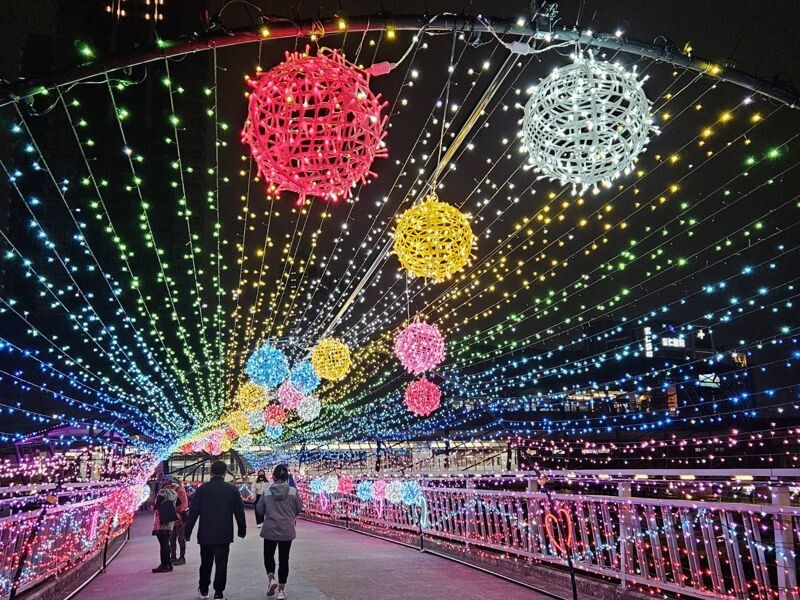拱型的炫彩光廊中,七彩的星星燈點綴著情人節的夜空。(新北高灘處提供)