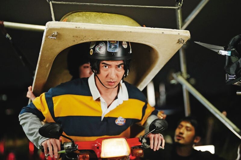 傅孟柏、柯佳嬿(上圖)扛浴缸騎機車的荒誕戲碼,拍攝過程出動大型拖板車,並利用鋼絲吊掛完成(下圖)。(Netflix提供)