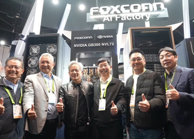 黃仁勳參觀鴻海GTC展位,在GB300 NVL72伺服器機櫃上簽名,劉揚偉隨後從一台機櫃中抽取一盒「鴻海巧克力」致贈,兩人合照留念。(翻攝自鴻海科技集團臉書)