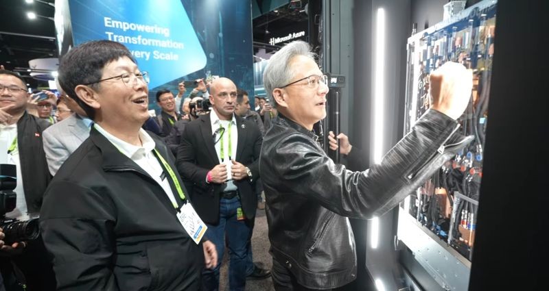 黃仁勳參觀鴻海GTC展位,在GB300 NVL72伺服器機櫃上簽名,劉揚偉隨後從一台機櫃中抽取一盒「鴻海巧克力」致贈,兩人合照留念。(翻攝自鴻海科技集團臉書)