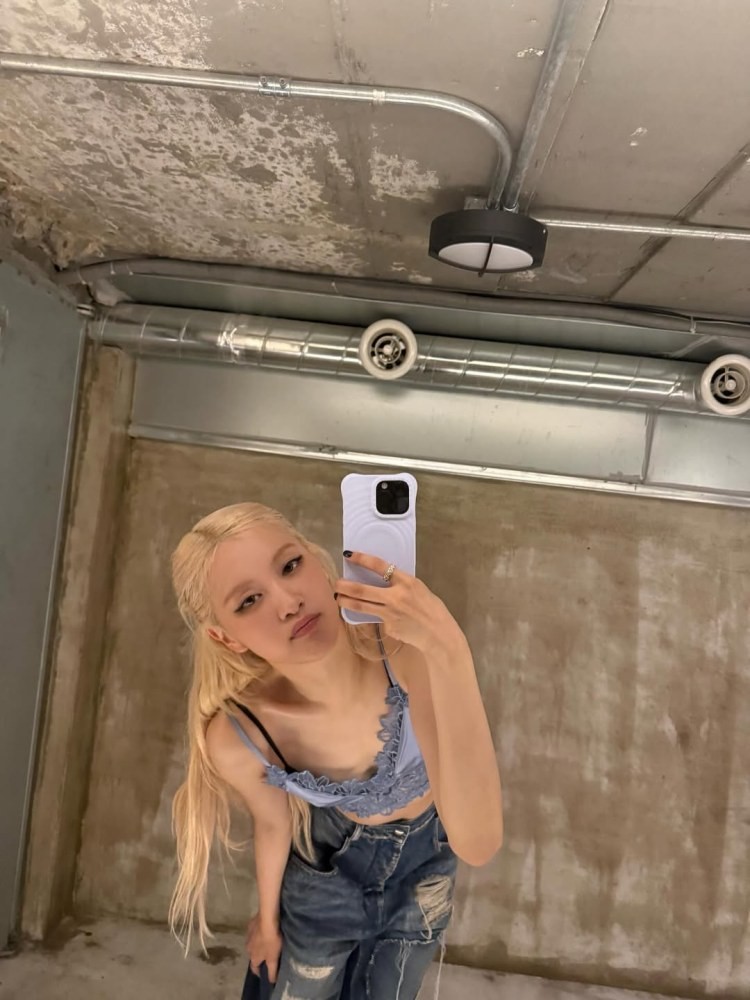 Rosé身穿藍紫色細肩蕾絲短上衣,搭配破壞感牛仔寬褲,在鏡子前自拍。