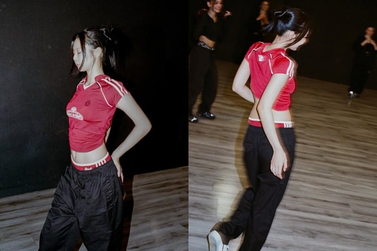 Jennie身穿紅色修身運動上衣，搭配黑色寬版長褲與外露的運動內褲，展現強烈動感與鮮明風格主張。