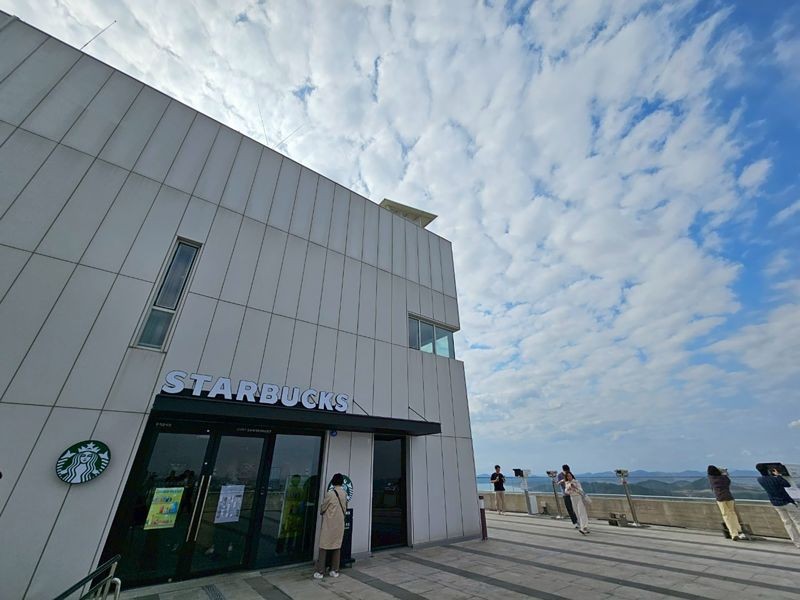 來到全球唯一的星巴克DMZ門市,手捧咖啡,窗外即是北韓的田野。(京畿觀光公社提供)