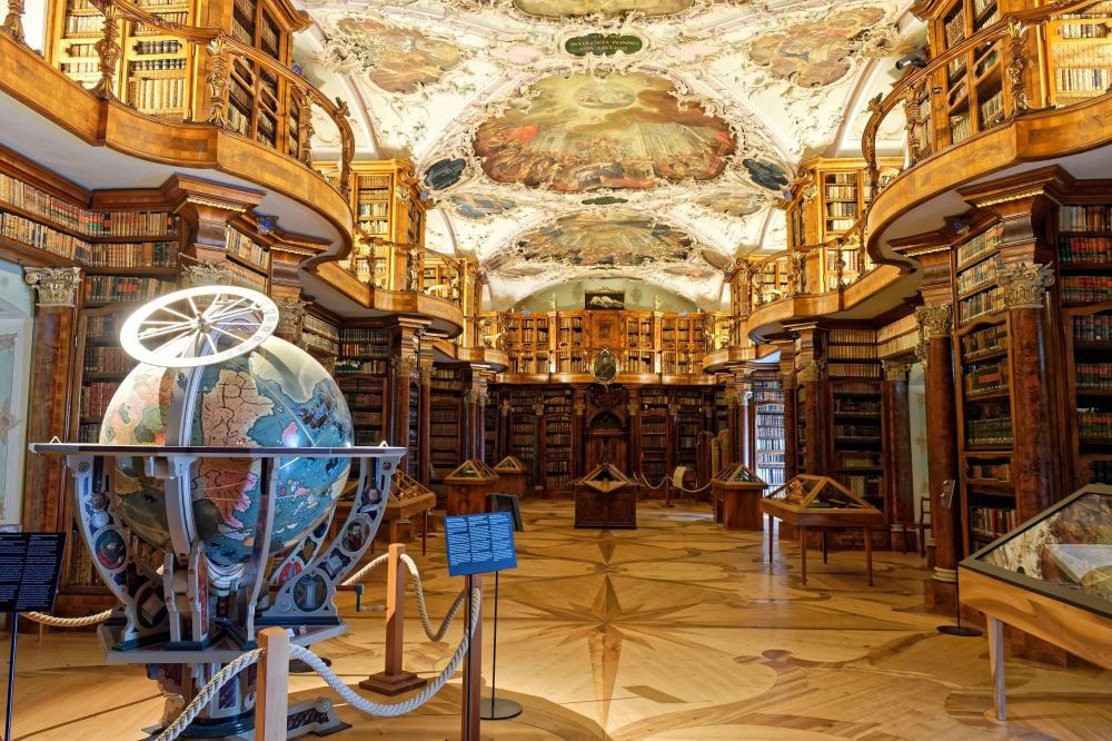坐落於瑞士東部的聖加侖市，聖加侖修道院圖書館（Abbey Library of St. Gallen）被譽為歷史最悠久、最具價值的修道院圖書館之一，其歷史可追溯至 8 世紀中葉。當年，愛爾蘭修士 Gallus 在此地建立類似現今的小型讀書會，隨著修道院逐漸發展，圖書館也隨之建立。其最令人驚嘆的亮點，是圖書館內保存完好的木質內裝與巴洛克風格天頂壁畫，值得一去。