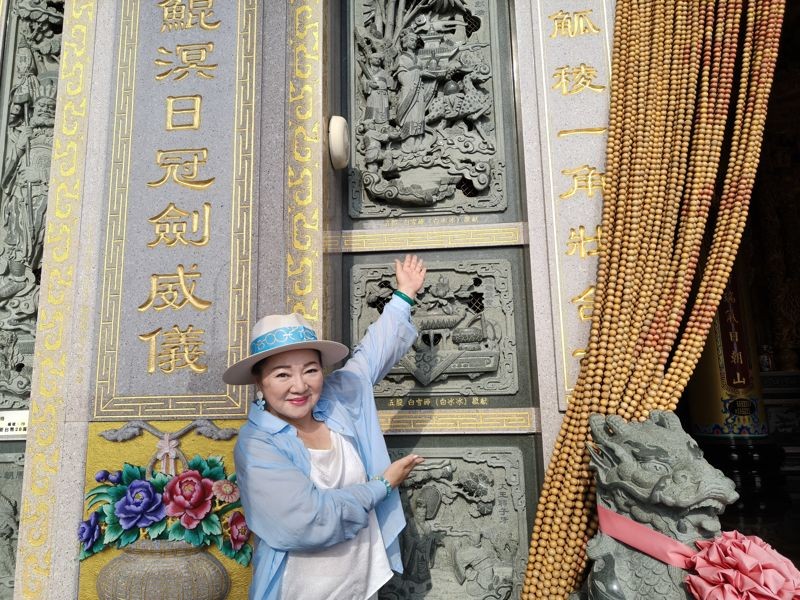 白冰冰在自己捐贈的石堵前拍照。(長興影視提供)