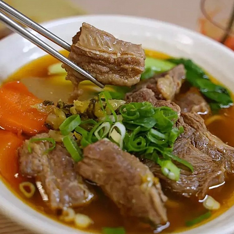九添福牛肉麵館的紅燒牛肉麵湯底有別於常見做法，不添加豆瓣醬，而是以牛腩配以醬油和大量蔬果燉煮，使湯頭帶自然香甜與牛肉清香。