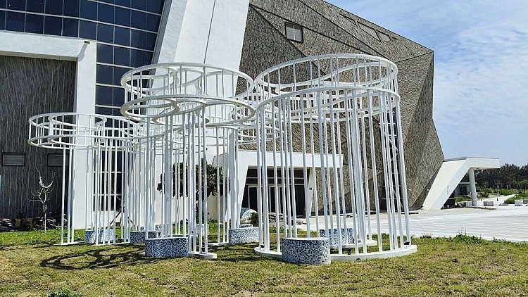 另一件，則是充滿寓意的《到海邊坐坐》，由好幾根鏤空圓柱組成，從下往上看，如同海面層層疊疊的波紋，一旁還有馬賽克拼貼的座椅，離開前，記得來這裡坐一坐吧。