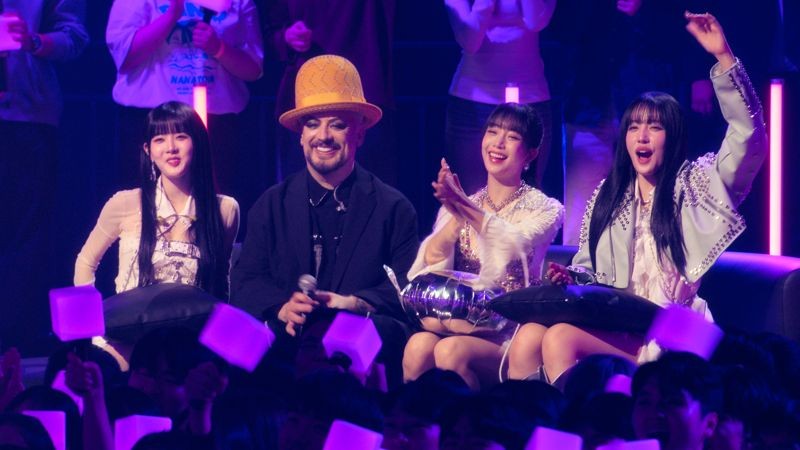 喬治男孩(左2)與韓團STAYC一起欣賞其他歌手的表演。(Apple TV+提供)