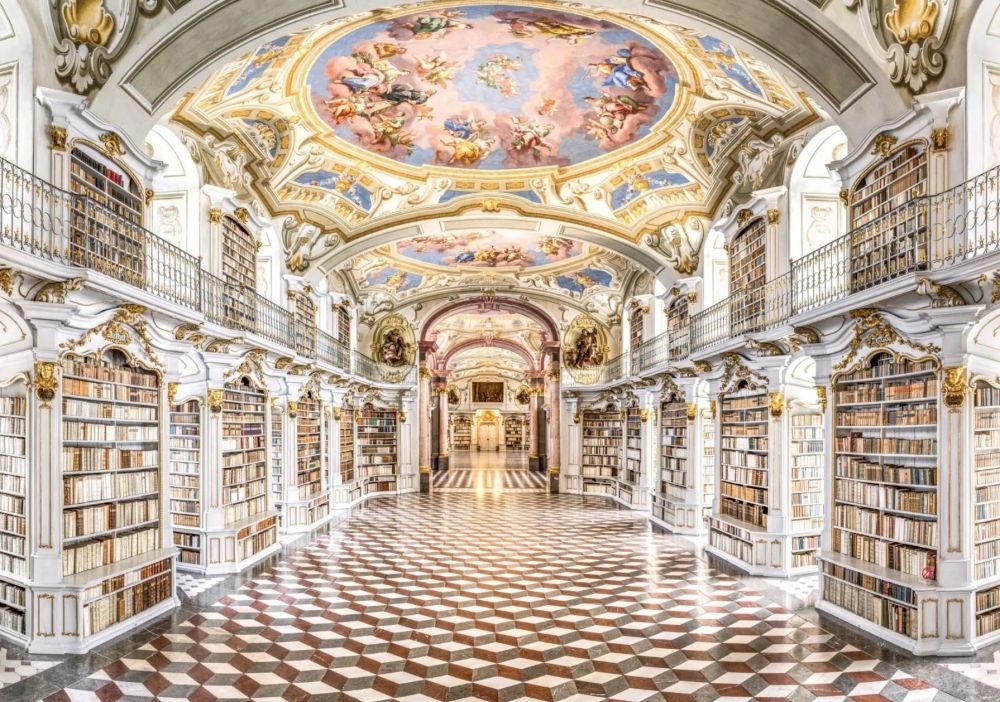 成立於 1776 年，坐落於奧地利阿德蒙特小鎮的阿德蒙特圖書館（Admont Abbey Library），是世界上規模最大的修道院圖書館，同時也是晚期巴洛克建築的華麗傑作。純白的建築主調搭配金色點綴，宛如走進一幅神聖的畫作，每一處細節都令人驚艷。抬頭可見色彩繽紛的天花板濕壁畫，也是迪士尼經典動畫《美女與野獸》中，壯麗圖書館場景的靈感來源之一。