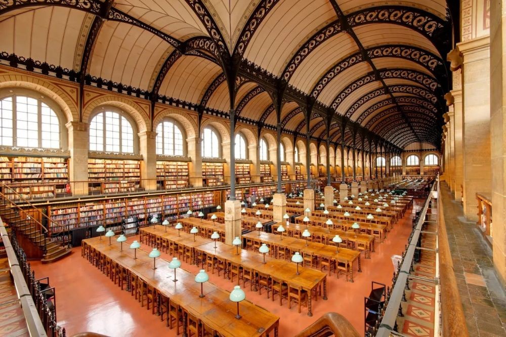 坐落於法國巴黎萬神殿（Panthéon）對面，聖熱納維耶芙圖書館（Sainte-Geneviève Library），是 19 世紀創新建築的代表作之一。館內雙拱形屋頂由細長的鑄鐵柱支撐，天花板上的格狀金屬結構為整體增添一抹精緻美感，在宏偉中展現優雅。這座圖書館不僅外觀典雅，內涵同樣深厚，其館藏源於 6 世紀的聖熱納維耶芙修道院，是一座極具歷史價值的文化遺產。