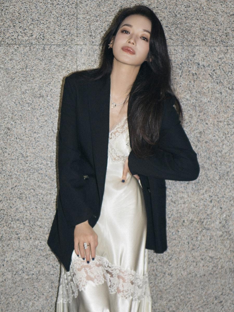 蕾絲與絲綢材質一向代表女性的柔美，但若單穿往往容易流於甜美或顯得成熟。舒淇選擇在淺米色蕾絲洋裝外搭剪裁俐落的黑色西裝外套，瞬間展現剛柔並濟的效果。這種 Mix & Match 的搭配不僅凸顯女性多層次魅力，也能修飾身形比例，讓浪漫與俐落氣息取得平衡，使整體造型更顯年輕有活力。她以此造型亮相影展，低調卻不失亮點，展現專屬她的自信與氣場。