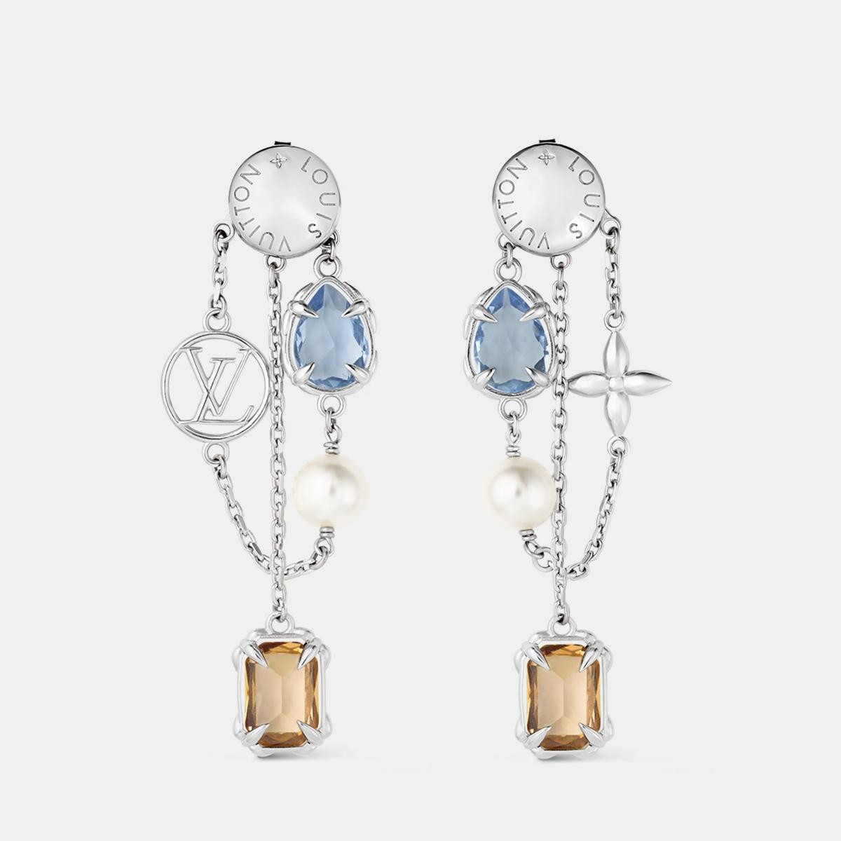 路易威登的 Heirloom Pendant 耳環是獻給魅力女性的最佳禮物。它以不對稱鍊帶串連彩色鋯石與樹脂珍珠,一側耳環飾以 LV Circle 標誌,另一側則綴以 Monogram 花卉圖案,搭配細膩的花卉造型爪鑲,展現出女性的多面與獨特。琥珀與水藍鋯石色調交錯,像晨光與夜幕的交替,柔美卻有力量。無論搭配白襯衫或絲質洋裝,皆能展現不費力的時髦。