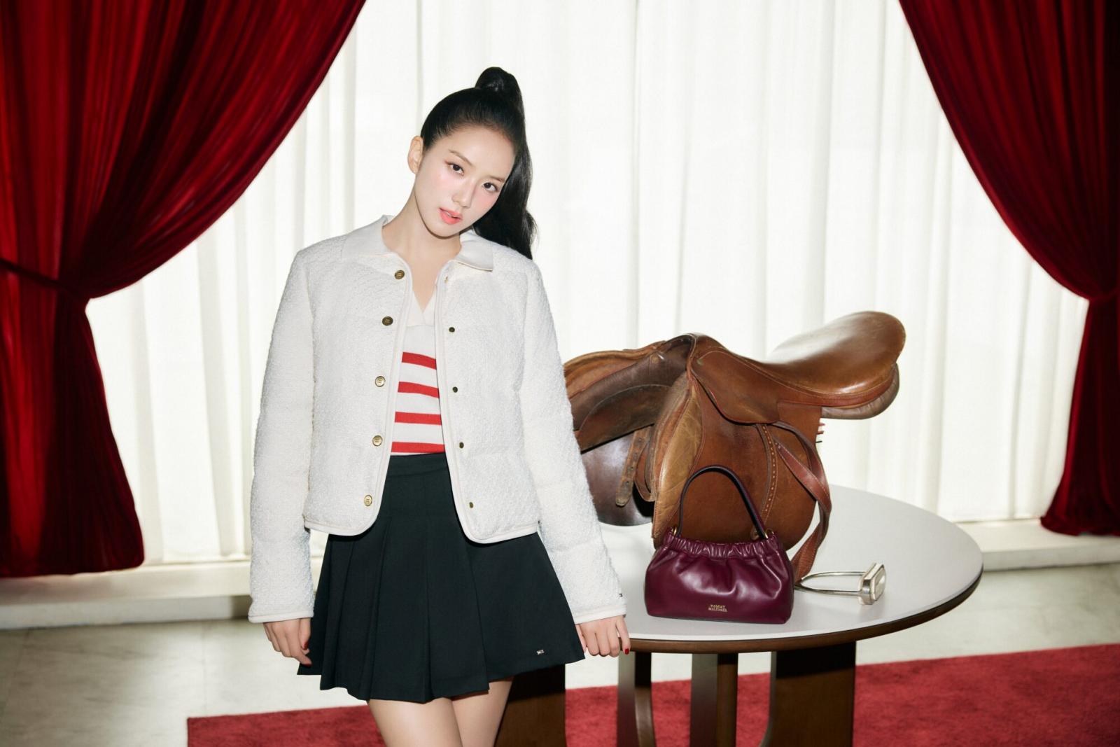 在多數人的印象裡,新年紅總是越多越好,但 Jisoo 這次示範的,反而是「紅色退一步」的穿法。她選擇以紅白條紋針織 Polo 作為內搭,讓紅色只存在於上半身的視覺焦點,既保留節慶象徵,也不會過度張揚。外層搭配象牙白絎縫外套,成功中和紅色熱度,也讓整體氛圍顯得清爽、乾淨。白色在這裡不只是陪襯,而是負責「降溫」與「定調」,讓紅色顯得更加細膩。下身搭配黑色百褶迷你裙與樂福鞋,則穩住整體比例,避免造型過度甜膩。這種配色邏輯特別適合過年走親訪友、需要長時間穿著的場合,不會因為顏色過重而產生視覺疲勞。對平常不習慣穿大紅的人來說,這是一個非常友善、也最不容易出錯的入門方式。