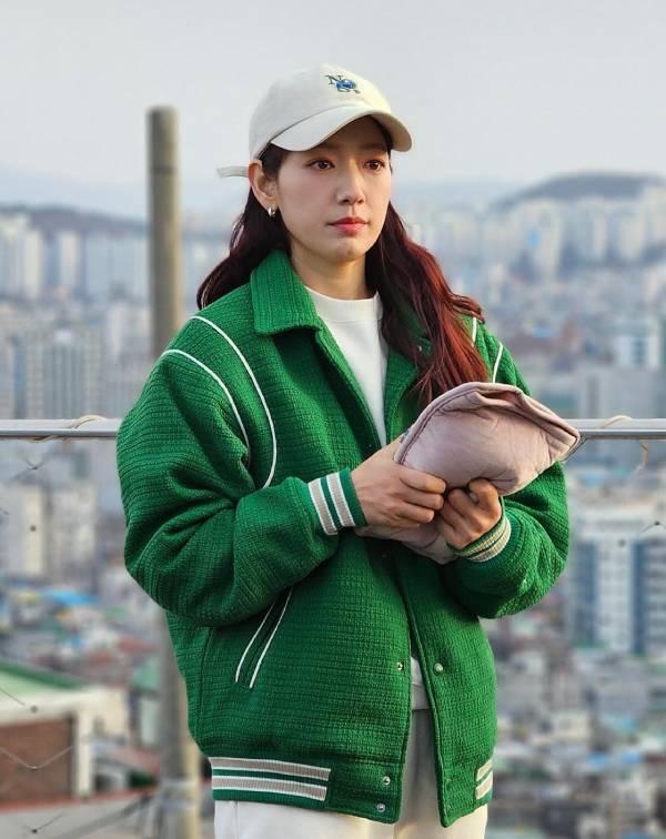 想要營造出有如朴信惠這種隨性、散發“︁元氣少女感”︁的氛圍?「棒球外套」與「大學T」的經典組合絕對是首選!這兩種時髦單品,不僅能完美修飾身型,那份鬆弛的褶皺感更帶出一種自在的慵懶與舒適,瞬間為穿搭注入了熱血的青春活力,展現出既俏皮又率性的美式感穿搭。