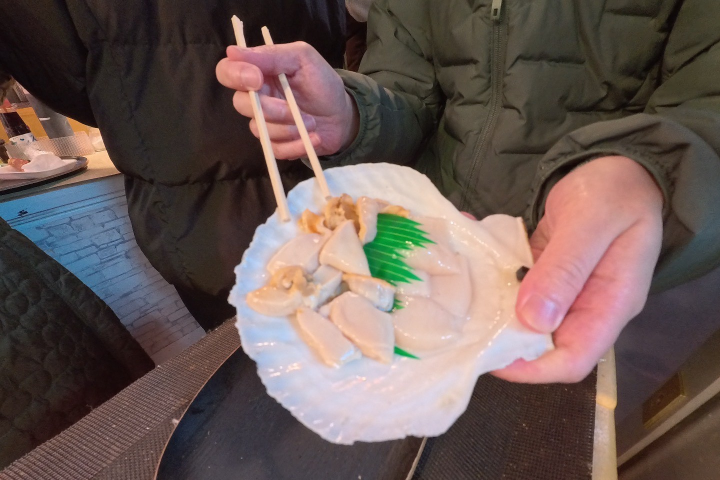 ▲新鮮的巨大帆立貝現切現吃非常鮮甜美味。　記者-游琮玄／攝影