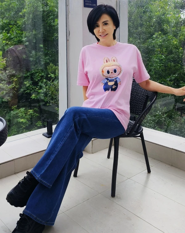 這張粉色穿搭照片最讓我驚豔的,莫過於田麗的「反差萌」!誰能想到昔日美豔動人的氣場女神,私下竟竟然也是紅遍全球的熱門玩偶Labubu小粉絲?!59歲的她穿上粉嫩色系的卡通T恤,非但沒有違和感,反而透出一種純真與俏皮。