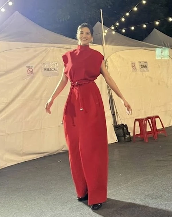 這套造型,完美示範了曾沛慈如何將「正紅色連身裙」穿出強大的女王氣場!她選用一件剪裁俐落的高領無袖長洋裝,極具建築感的廓形與大膽的紅,讓她在夜色中依然閃耀奪目。這套穿搭最神來一筆的細節,在於她巧妙利用同色系的細皮帶繫在腰間,並隨性垂下,這個舉動不僅抓出了明顯的腰身比例,更在簡約中增添了靈動感,成功打破長洋裝容易顯得厚重的沉悶感。