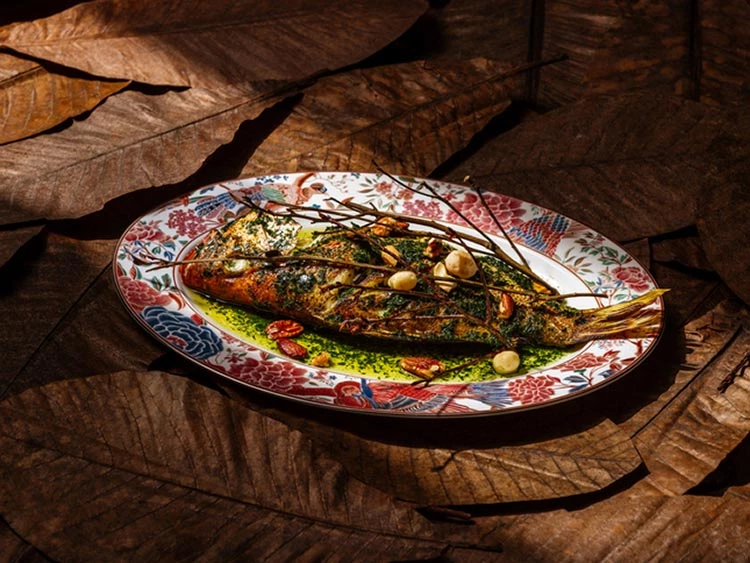 滿月樓姜家茶金宴中的「酸桔葉烤鮮魚」,以澎湖直送鮮魚結合酸桔葉燻油、鹽麴與酒釀炙烤,口感鮮嫩細緻。