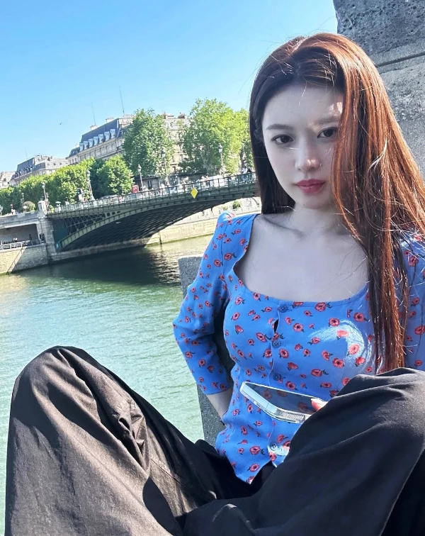 高允貞的這套,單品乍看好似很隨性,但其實細究的話,不難發現她隨手一來的搭配巧思。本身帶點法式甜感的藍色小碎花方領上衣,加上微貼身剪裁和鎖骨露出,既清新又有一點女人味,但同時,她還很聰明地用一條寬鬆黑色長褲去中和,瞬間把整體拉回偏率性、帶點慵懶的街頭感,甜而不膩。再加上幾乎沒有多餘配件、妝髮也走自然路線,讓重點回到版型和配色本身,整體就是一種不費力卻很有氛圍的時髦感。