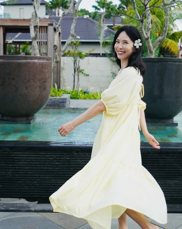 淡黃色澎袖長洋裝,自帶一種南法莊園的度假濾鏡,天心聰明地選擇了柔和的奶油黃,不僅比死白更具亮膚效果,寬鬆的傘擺與微澎袖型更能無痛遮肉、視覺減重。一般人想要複製這份不費力的仙氣,關鍵在於浪漫配飾與色彩的減法,日常穿搭時,不妨挑選低飽和度的初戀色系(如:淡藍、淺綠),並學天心在髮際側邊點綴一朵乾淨的白色花朵或度假感髮夾,腳下隨性踩一雙平底涼鞋或草編鞋,就能把甜美與慵懶拿捏得恰到好處,轉身就散發讓人怦然心動的少女氣息。