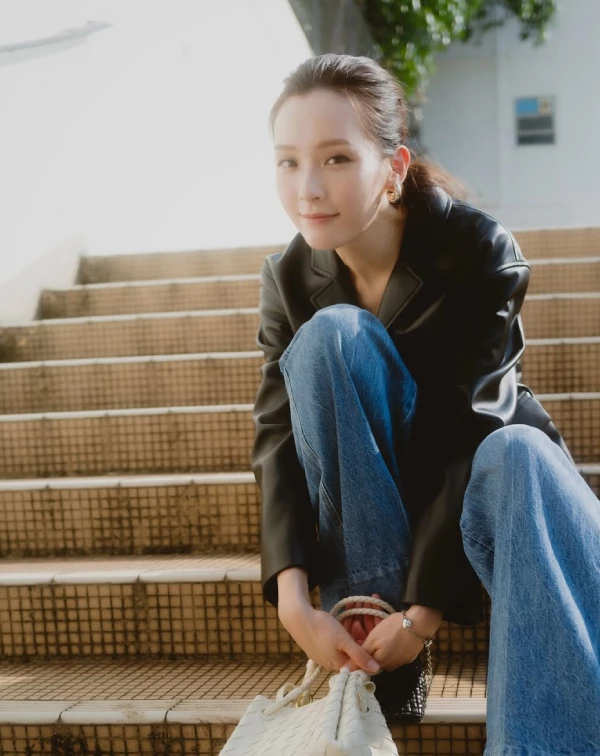 李佳芯示範了我們這個40+年紀最該學會的「優雅叛逆」。很多人到了40歲不敢碰皮衣,怕顯得太硬派或刻意刻薄,但你看她聰明地選擇剪裁俐落的黑色軟質皮衣,內搭一件簡單的素色上衣,下半身直接套上寬鬆的刷色高腰牛仔褲。