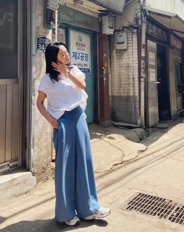 如果說白色是減齡聖品,那這張照片裡的徐令姬,簡直是代名詞!這種明亮的藍、白色系搭配,瞬間讓她的氣色看起來既清爽又時髦得毫不費力。我們這個年紀的女性,夏天一定要學會用「亮點色」來提亮自己。別再只敢穿全身黑或卡其色了!試著像她一樣,用「白上衣+藍色褲」打造清爽逆齡感。既能有吸睛的視覺效果,又不會顯得過於突兀,絕對是我們顯年輕、顯好氣色的秘密武器。