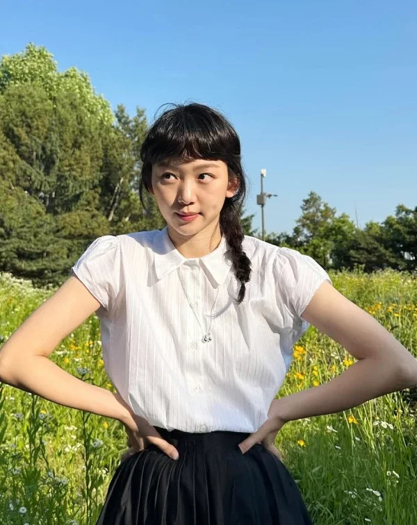 這種「黑、白配」雖然看著簡單,但短袖微澎的袖口設計與胸前的細緻銀鍊,都默默為秦基周注入了少女心,在陽光下閃閃發亮。當衣著顏色很基本時,就可以運用髮型和飾品來加分!像這樣穿上素色裙裝時,順手綁個隨性的側編辮子或丸子頭,再搭一條精緻的細項鍊,就能穿出夏日田園風的清爽與年輕感。