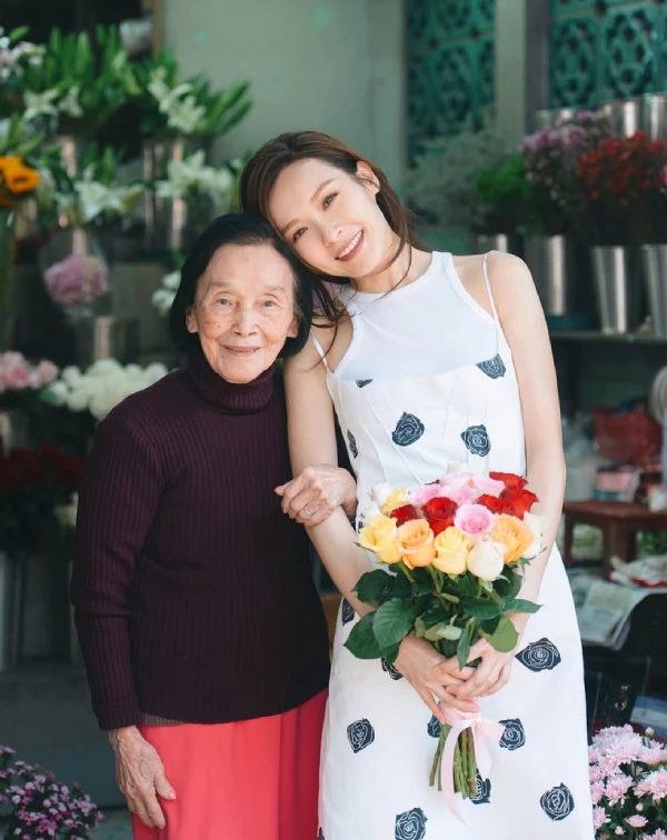 很多同齡女性擔心單穿細肩帶洋裝會露手臂或顯得太過性感,李佳芯給了我們一個教科書級的解答:「雙層疊穿」。第一步,先穿上一件極簡的純白削肩無袖背心,接著疊穿上帶有黑色幾何玫瑰印花的細肩帶白洋裝。這個技巧,巧妙地遮蔽了可能讓人自在的副乳或過多裸露感,卻保留了細肩帶的清爽與浪漫。整體色調保持乾淨的黑與白,不僅襯托出極佳的氣色,走在街頭更是滿滿的鄰家姐姐好感度。