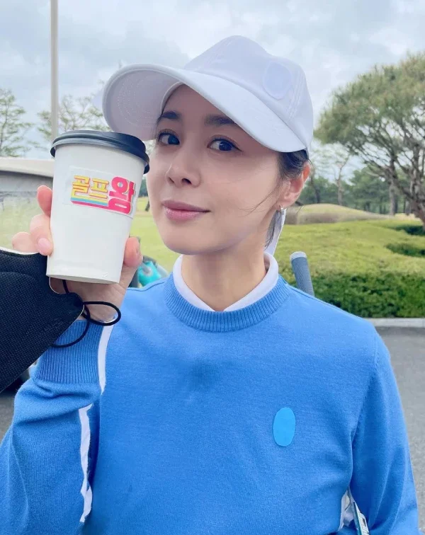 看到這張徐令姬在戶外球場的自拍照角度,還真有點像港星關之琳啊〜我真的被她的狀態給美到了!一件飽和度高、極具朝氣的天空藍圓領針織衫,內搭白色小立領製造層次,頭上則配戴一頂白色棒球帽。沒有多餘的彩妝和華麗首飾,這種「藍 + 白」的乾淨配色,在陽光下就像一劑天然的視覺防腐劑,整個人散發出一股無雜質的減齡感,誰能相信她47歲了?