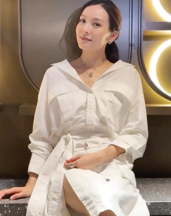 如果你想找一套應付正式場合或約會、卻又不想穿得太無聊的戰袍,看看李佳芯的這套全白襯衫式連身裙吧!看似簡單,心機全在細節裡。首先,故意不把領口扣死,微微往後拉成V領,露出漂亮的鎖骨鏈;第二步,一定要綁上同款式的寬版腰帶,抓出腰身與下半身的比例。這套衣服的精髓在於裙襬隱約的開衩,當你坐下時微微露腿,配上乾淨的低馬尾,那種由內而外散發的鬆弛感與高級知識份子氣質,真的比任何緊身衣都還要吸引人。