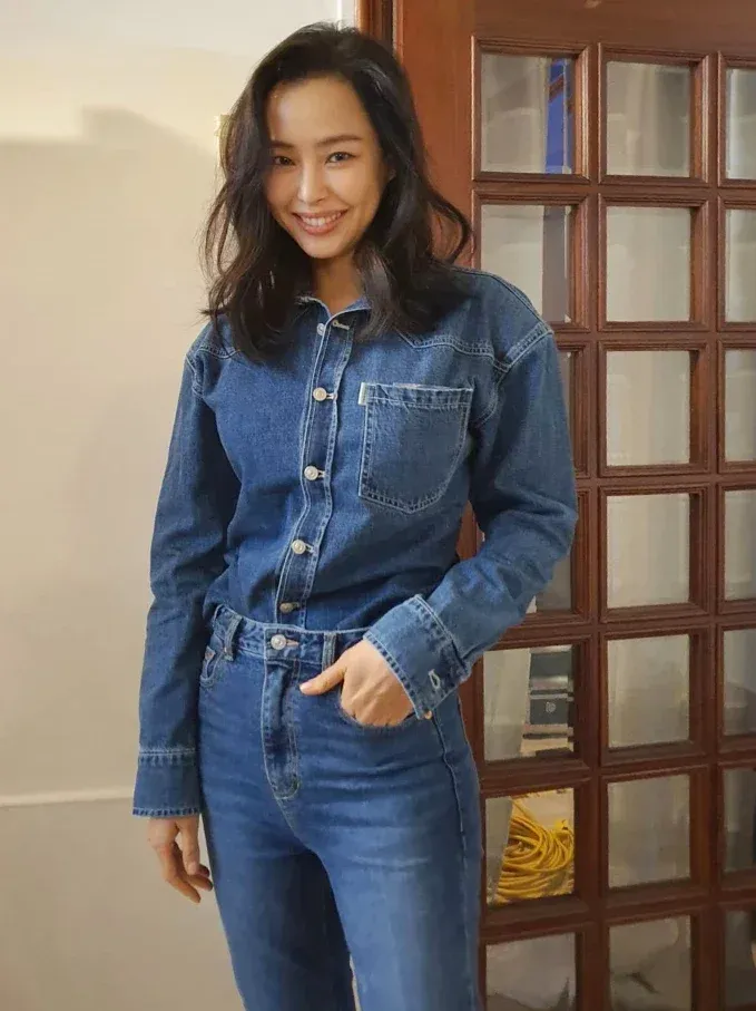 Denim on Denim,一直都是時尚界不敗的減齡神技!李荷妮的這套,直接將修長比例拉到極致。不用過多的飾品堆疊,光靠牛仔布料本身的硬挺質感與大方笑顏,就展現出強烈的個人氣場。牛仔單品是無痛減齡的首選!但全套丹寧穿搭時,記得將襯衫紮入褲頭,或者稍微拉高腰線,利用質感硬挺的面料來修飾身形線條,立顯俐落精神。