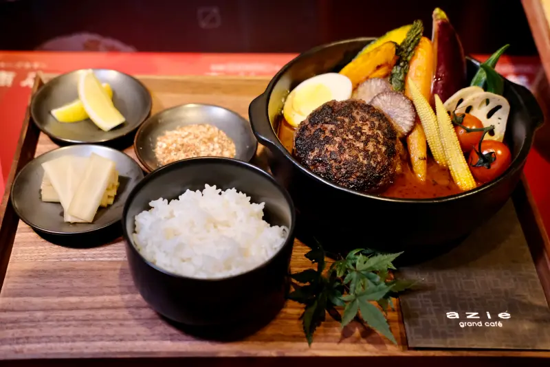 ▲「奧芝商店」進駐晶華酒店，湯咖哩內除了主菜漢堡排，還有多樣蔬菜，並搭配小菜、拉昔與白飯做成套餐。（圖／記者葉盛耀攝）