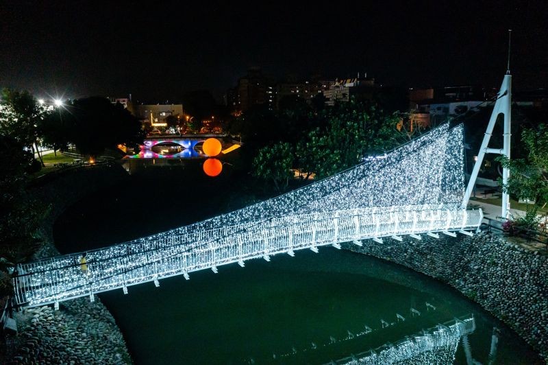 萬年溪蜿蜒的河體呼應龍年，「星織天橋」在橋上點滿星光。（屏東縣政府提供）