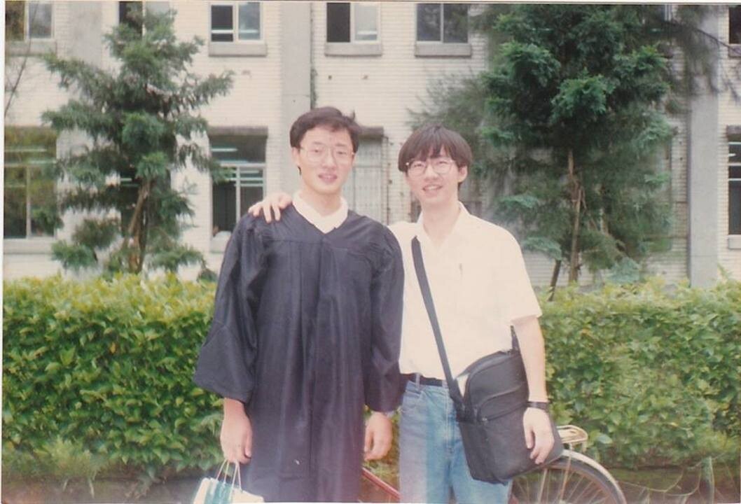 大學畢業前夕，筆者（右）在校園撞見好友在拍畢業照，合拍了一張。（王文華Facebook）