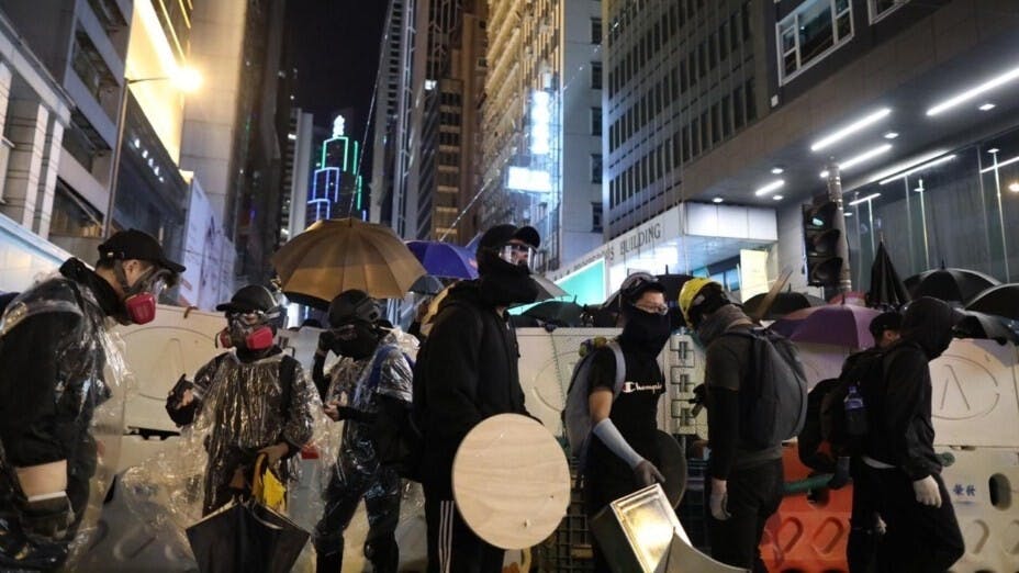 入夜後，黑衣示威者阻塞德輔道中。（亞新社）