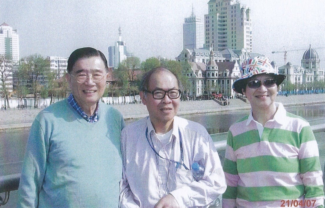 2007年4月7日，李龍鑣夫婦與陳明銶教授（中）合影於天津市海河之濱。背後紅瓦及有光塔的建築物便是袁世凱故居。