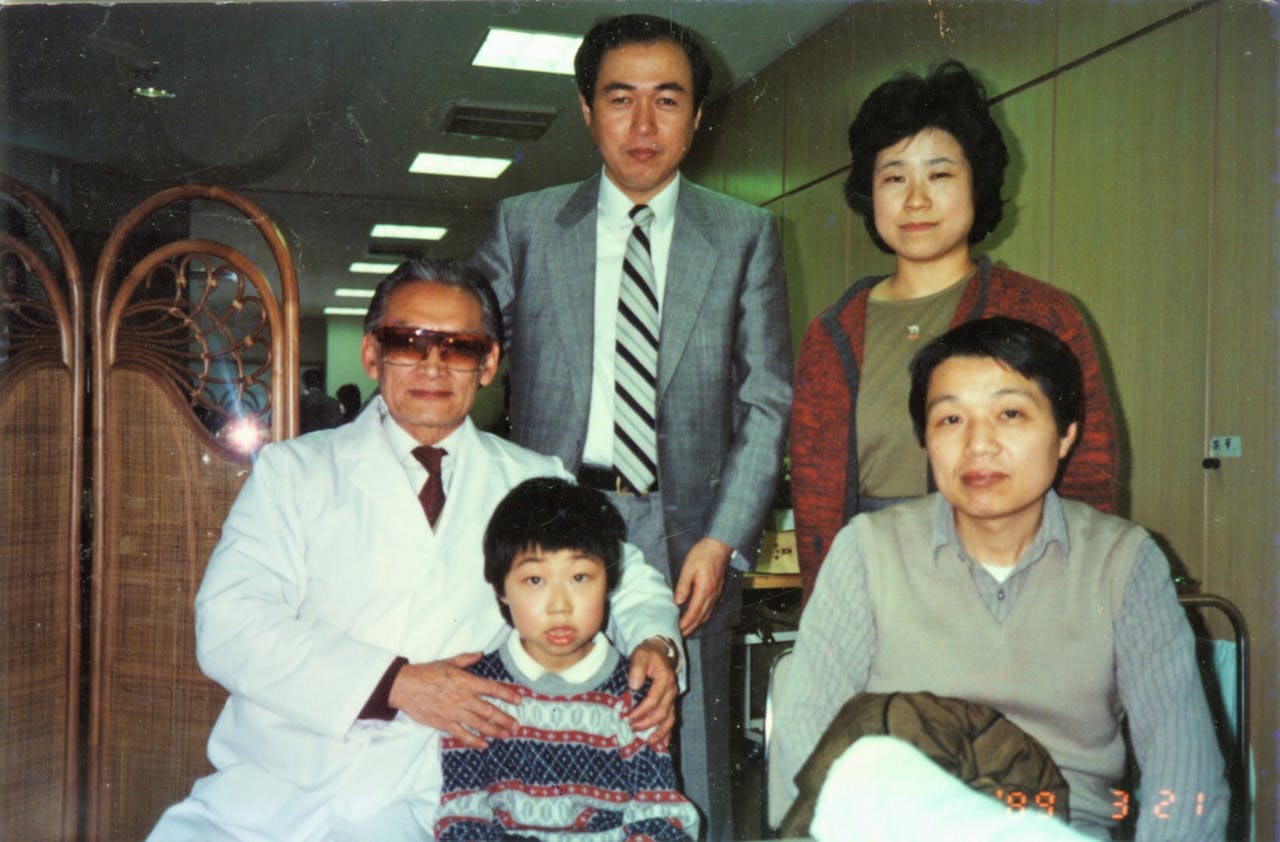 經過治療後，病童視力回復。後立為神戶醫院院長，右邊坐立者分別為病童父母。