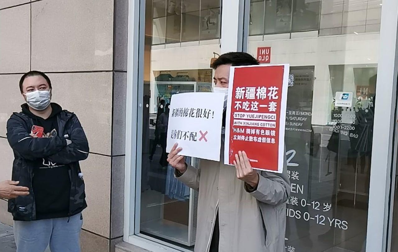 在四川成都一家H&M服裝門市店外，一名男子手持標語牌，抗議有關品牌與新疆棉花「割席」。（亞新社）