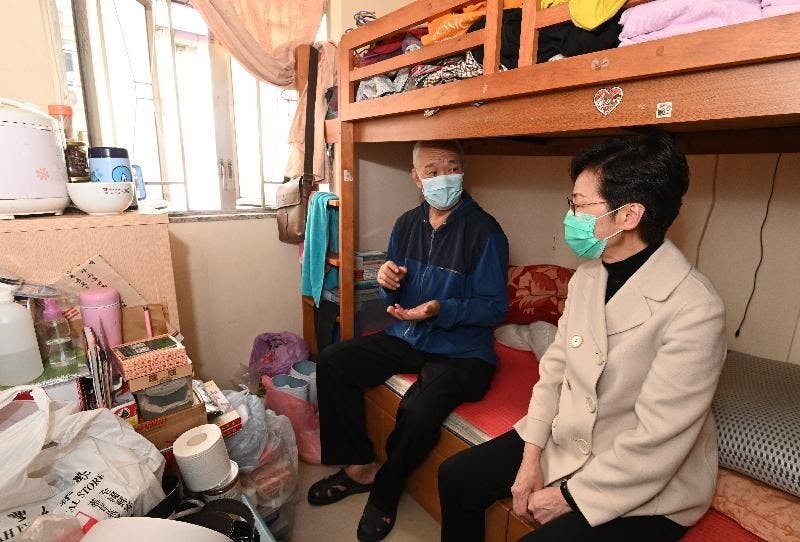 行政長官林鄭月娥（右）今日下午到訪深水埗，向居於「劏房」的長者派發口罩等防疫用品。（政府新聞處）