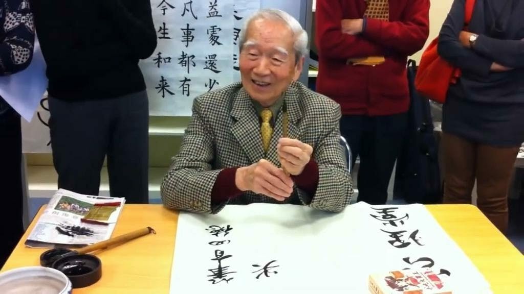 昵稱樂翁的王齊樂教授鶴髮童顏、精神矍鑠，手持硃砂毛筆，圈點批文，精要講解，也作示範。（YouTube影片截圖）