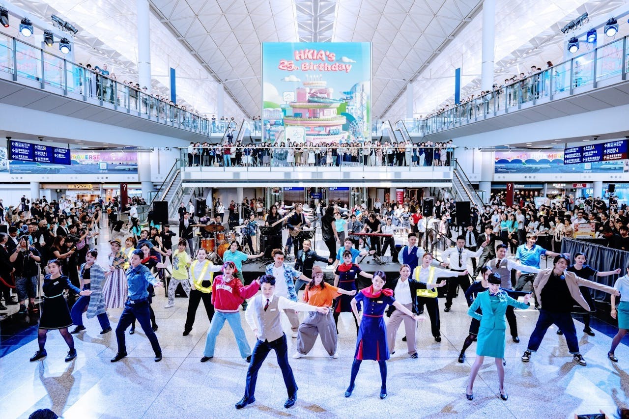 香港國際機場慶祝成立25周年，民航從業員聯同歌手在機場表演歌舞。（香港國際機場Facebook）