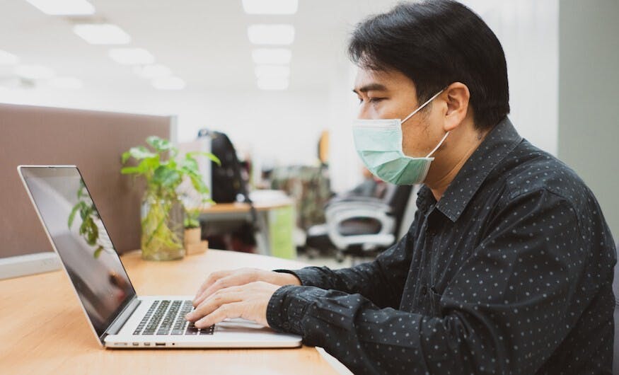 在疫情嚴峻下，不少公司安排員工在家工作，上班的員工也在辦公室佩戴口罩。（Shutterstock）
