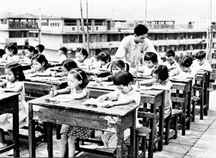 1954年政府文件承認建校速度未能達標，容許政府興建的公共房屋（七層大廈）出現天台學校、底層學校。（Wikimedia Commons）