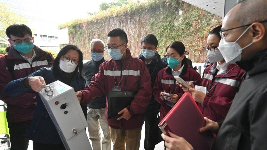 當局繼續在多區檢測污水，圖為渠務署在臨時監測站向內地專家示範抽取污水樣本。（政府新聞網圖片）