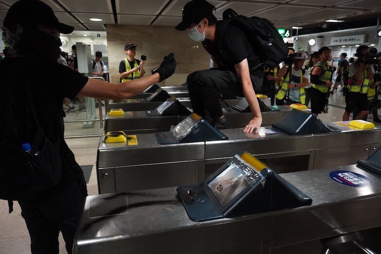 示威者把對政府、對警察的怨氣發泄到港鐵身上，除了破壞港鐵站內的設施、閘機，還呼籲「免費搭港鐵」。（亞新社）