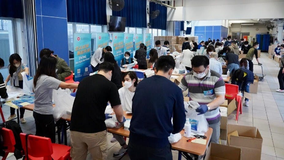 政府今日（2日）開始向全港市民派發防疫服務包，特首希望市民可用服務包內的快速檢測套裝，自願檢測若呈陽性，24小時內呈報結果。圖為設於荃灣天主教小學的包裝中心。（聶德權Facebook圖片）